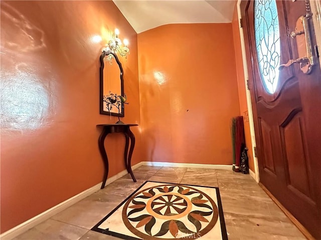 foyer featuring light tile patterned floors and lofted ceiling