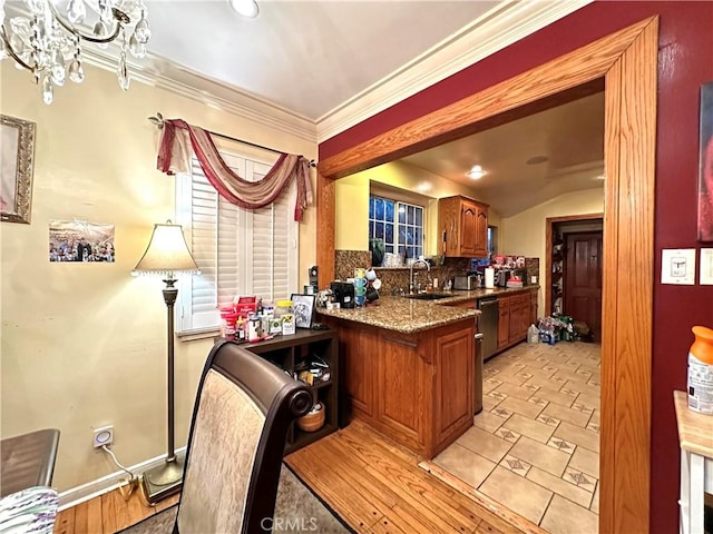 kitchen featuring stone counters, tasteful backsplash, sink, kitchen peninsula, and crown molding