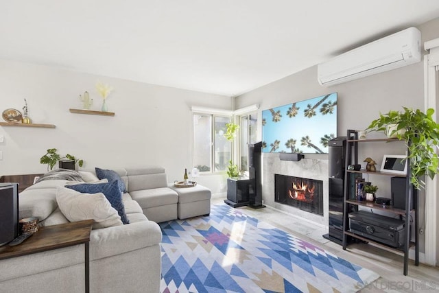 living room featuring light wood-type flooring, a wall mounted AC, and a premium fireplace