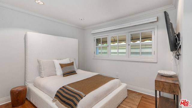 bedroom featuring hardwood / wood-style flooring and crown molding