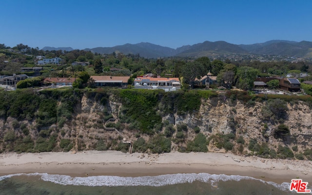 aerial view featuring a water and mountain view and a view of the beach