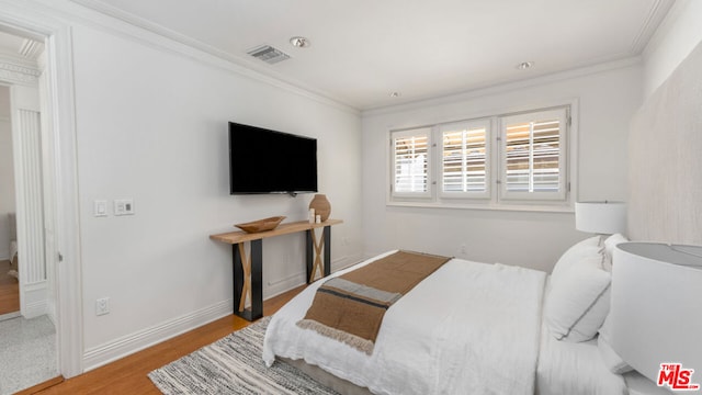 bedroom with light wood-type flooring and ornamental molding