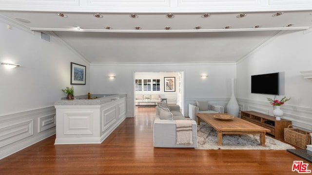 living room with hardwood / wood-style flooring, crown molding, and lofted ceiling