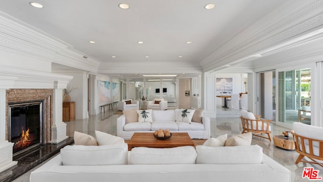 living room featuring crown molding and a high end fireplace