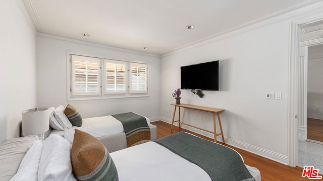 bedroom with crown molding and dark wood-type flooring