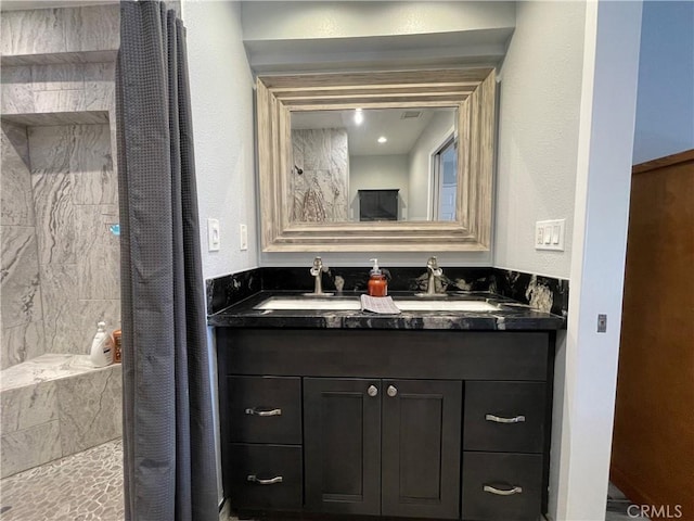 bathroom with curtained shower and vanity