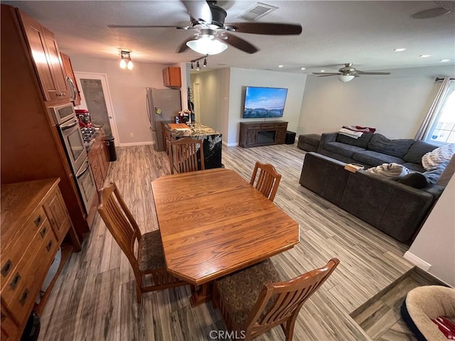 dining space with sink, ceiling fan, and light hardwood / wood-style flooring