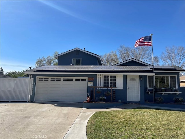 view of front of property with a garage, a front lawn, and solar panels