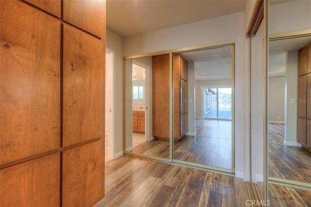 hallway with hardwood / wood-style flooring