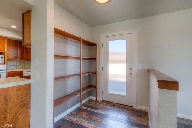 entryway with recessed lighting, dark wood-style floors, and baseboards