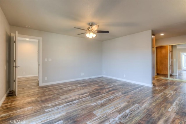 spare room with ceiling fan and dark wood-type flooring