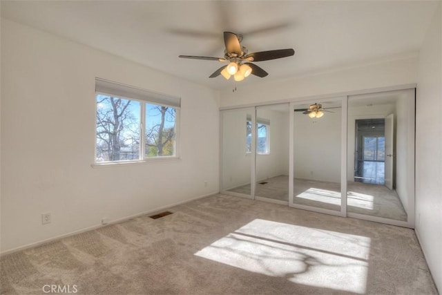 unfurnished bedroom with carpet floors, a closet, ceiling fan, baseboards, and visible vents