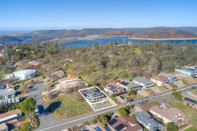 aerial view featuring a water view, a view of trees, and a residential view