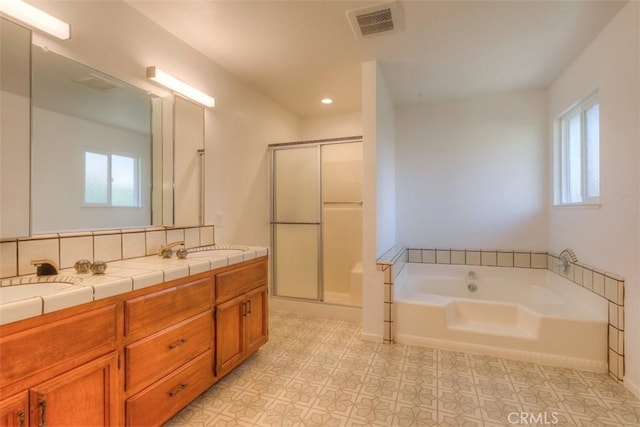 bathroom featuring backsplash, vanity, and separate shower and tub