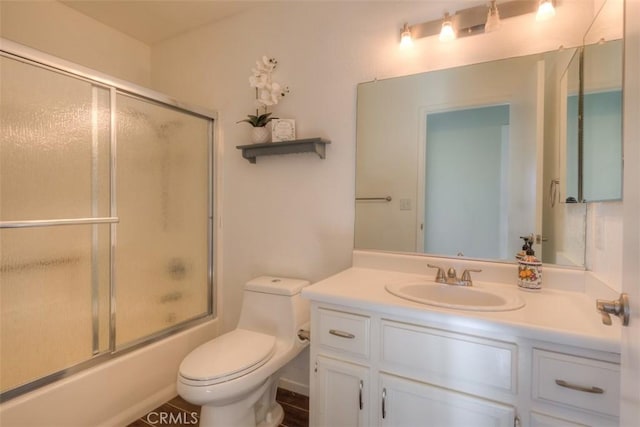 full bathroom with shower / bath combination with glass door, toilet, and vanity