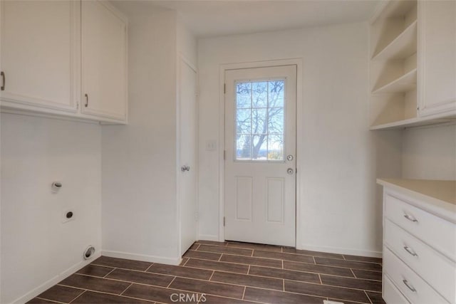 clothes washing area with cabinet space, hookup for an electric dryer, wood tiled floor, and baseboards