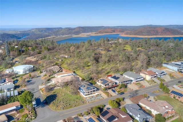 birds eye view of property with a wooded view, a water view, and a residential view