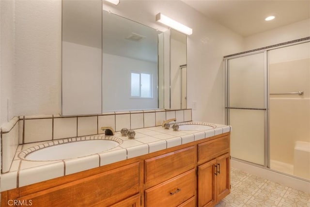 bathroom with backsplash, an enclosed shower, and vanity