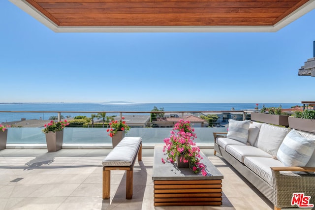 balcony with an outdoor living space and a water view