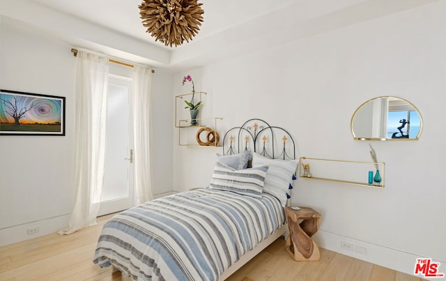 bedroom featuring multiple windows and light hardwood / wood-style flooring