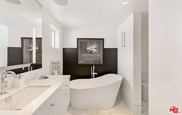 bathroom featuring a bath, toilet, and vanity