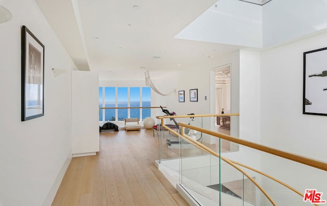 hallway featuring light hardwood / wood-style flooring and a water view