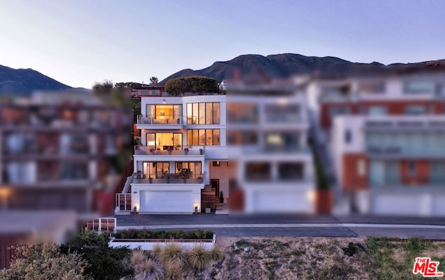 back of property with a garage and a mountain view