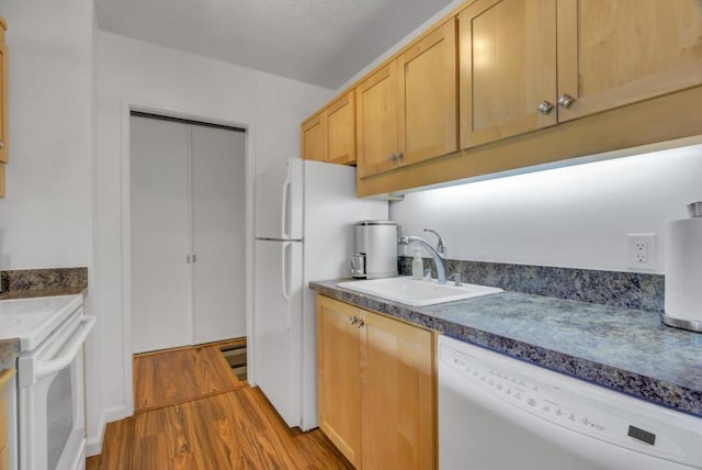 kitchen featuring sink, white appliances, light brown cabinets, and light wood-type flooring