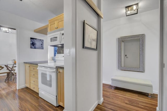 kitchen featuring white appliances, dark hardwood / wood-style floors, and light brown cabinets