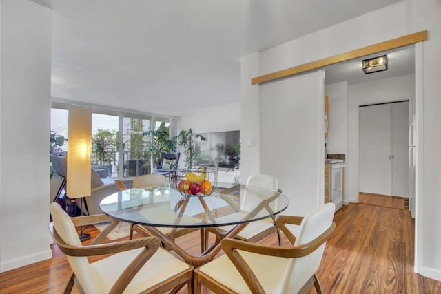 dining space featuring hardwood / wood-style flooring and a wall of windows