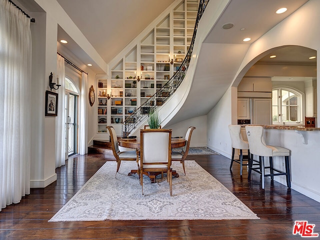 dining space with built in shelves, dark hardwood / wood-style flooring, and lofted ceiling