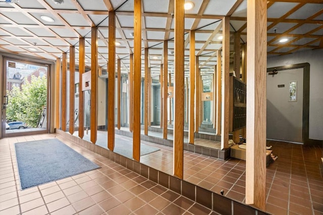 interior space featuring tile patterned flooring and coffered ceiling