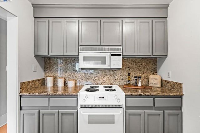 kitchen with white appliances, gray cabinetry, and tasteful backsplash