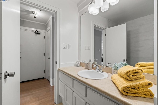 bathroom with vanity, hardwood / wood-style floors, and ornamental molding