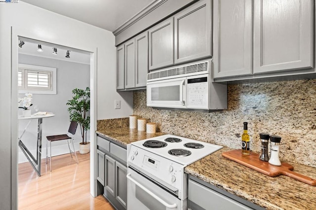 kitchen with backsplash, white appliances, gray cabinetry, and stone counters