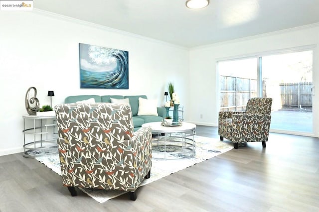 living area with hardwood / wood-style floors and crown molding