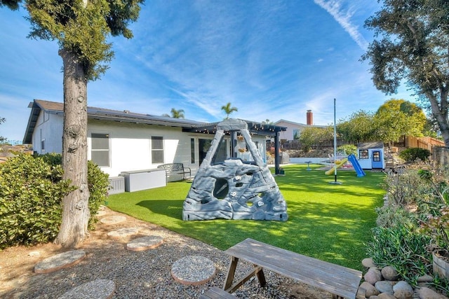 exterior space with a playground, a storage shed, and a lawn