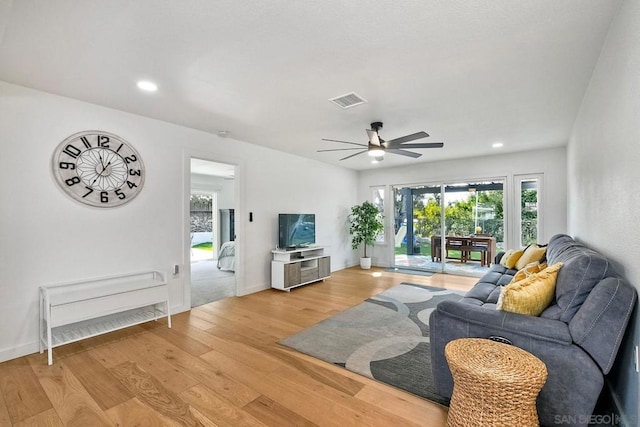 living room featuring hardwood / wood-style floors and ceiling fan