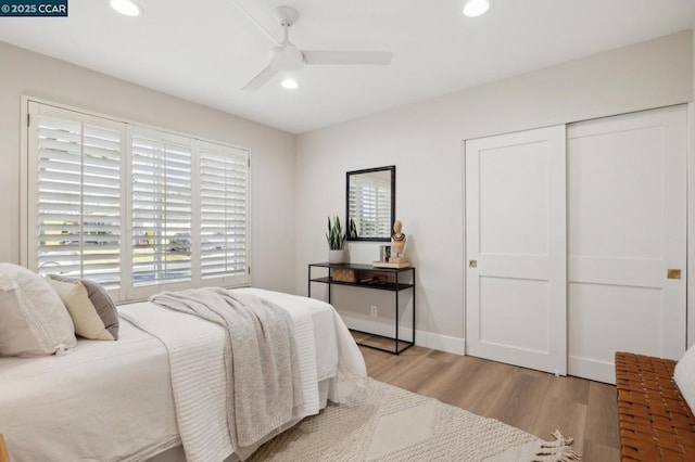 bedroom featuring light wood-type flooring, ceiling fan, and a closet