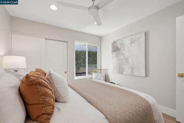 bedroom with ceiling fan, wood-type flooring, and a closet