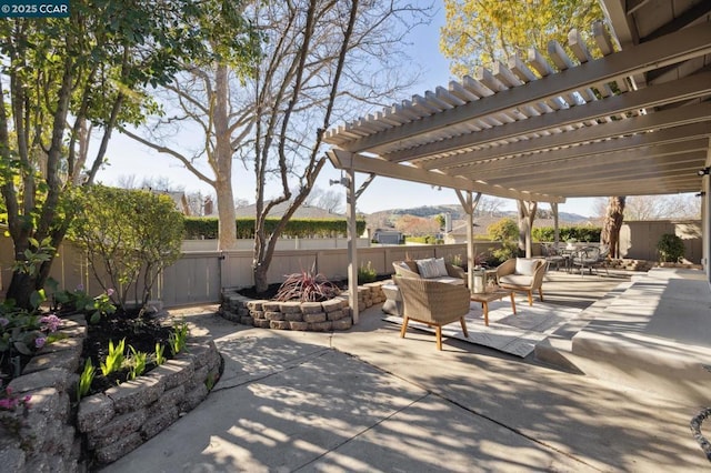 view of patio featuring a mountain view, a pergola, and an outdoor living space with a fire pit