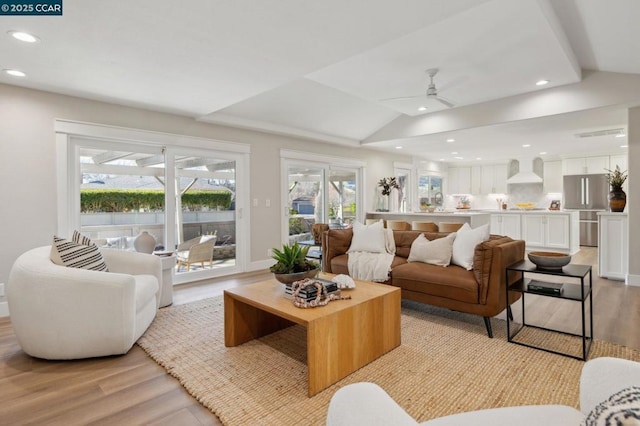 living room with vaulted ceiling, ceiling fan, and light hardwood / wood-style floors