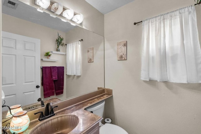 bathroom featuring toilet and vanity