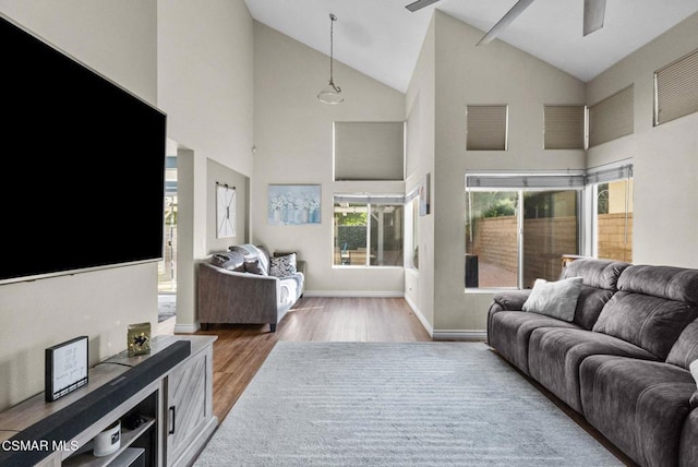 living room with ceiling fan, high vaulted ceiling, and wood-type flooring