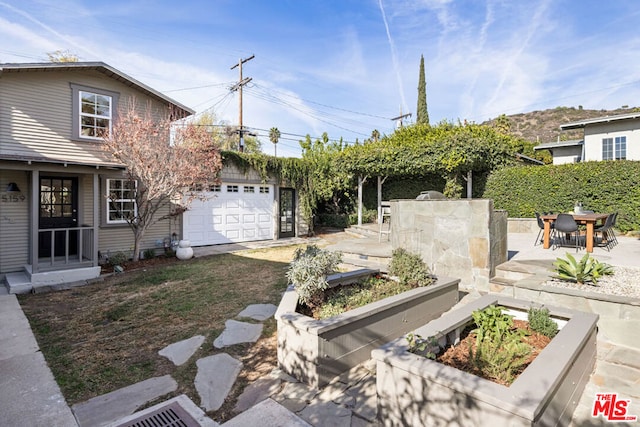 view of yard featuring a patio and a garage