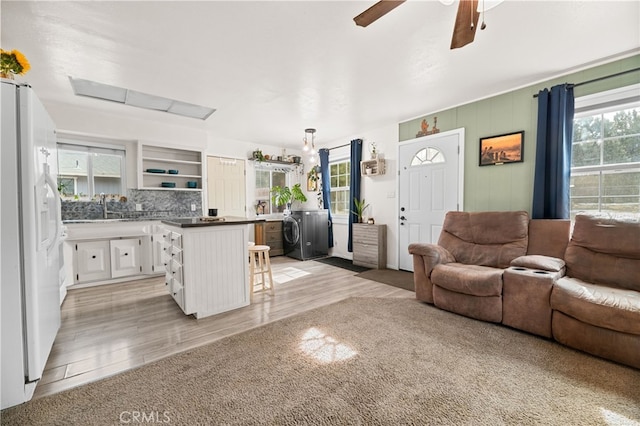 living room with ceiling fan, washer / clothes dryer, and sink