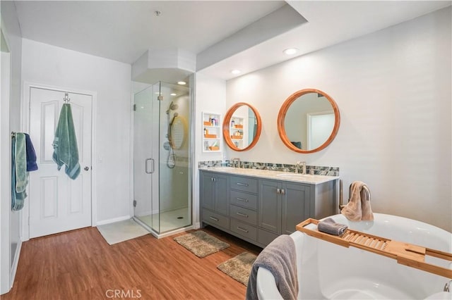 bathroom featuring hardwood / wood-style floors, walk in shower, and vanity