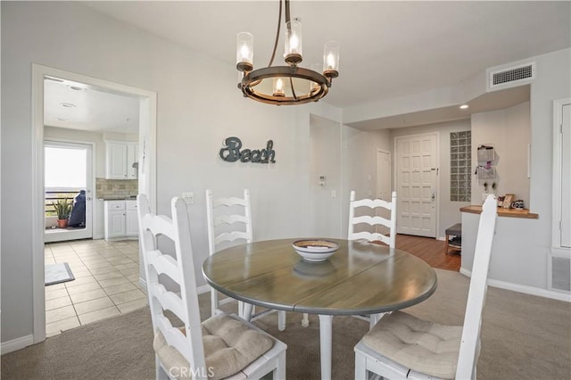 dining space with a chandelier and tile patterned flooring