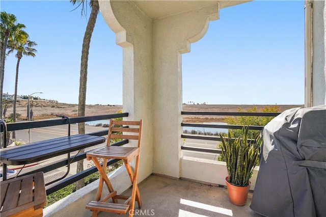 balcony with area for grilling and a water view