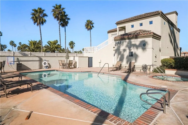 view of swimming pool with a community hot tub and a patio area